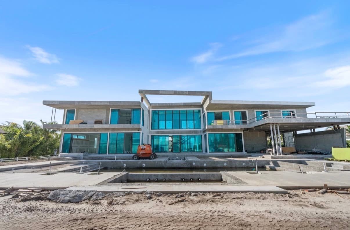 Large modern home with extensive glass windows and pool construction