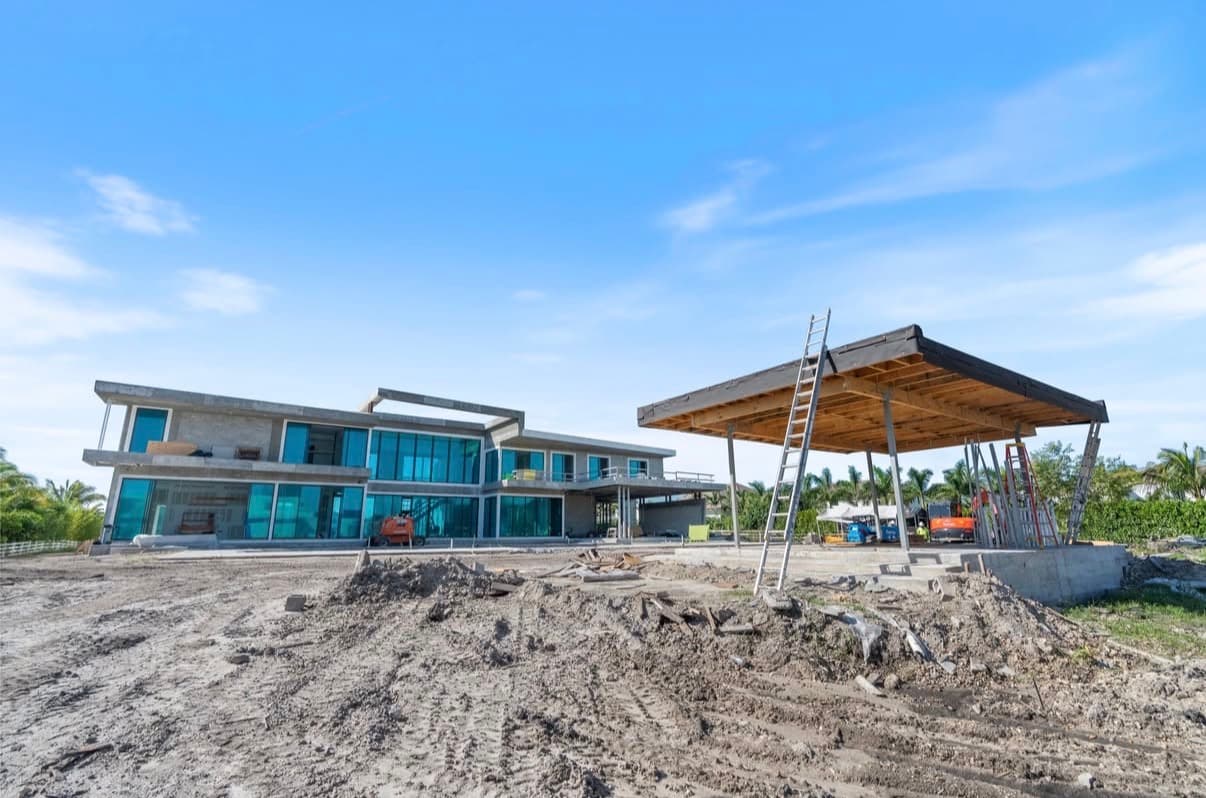 Wide view of luxury home construction with separate cabana structure